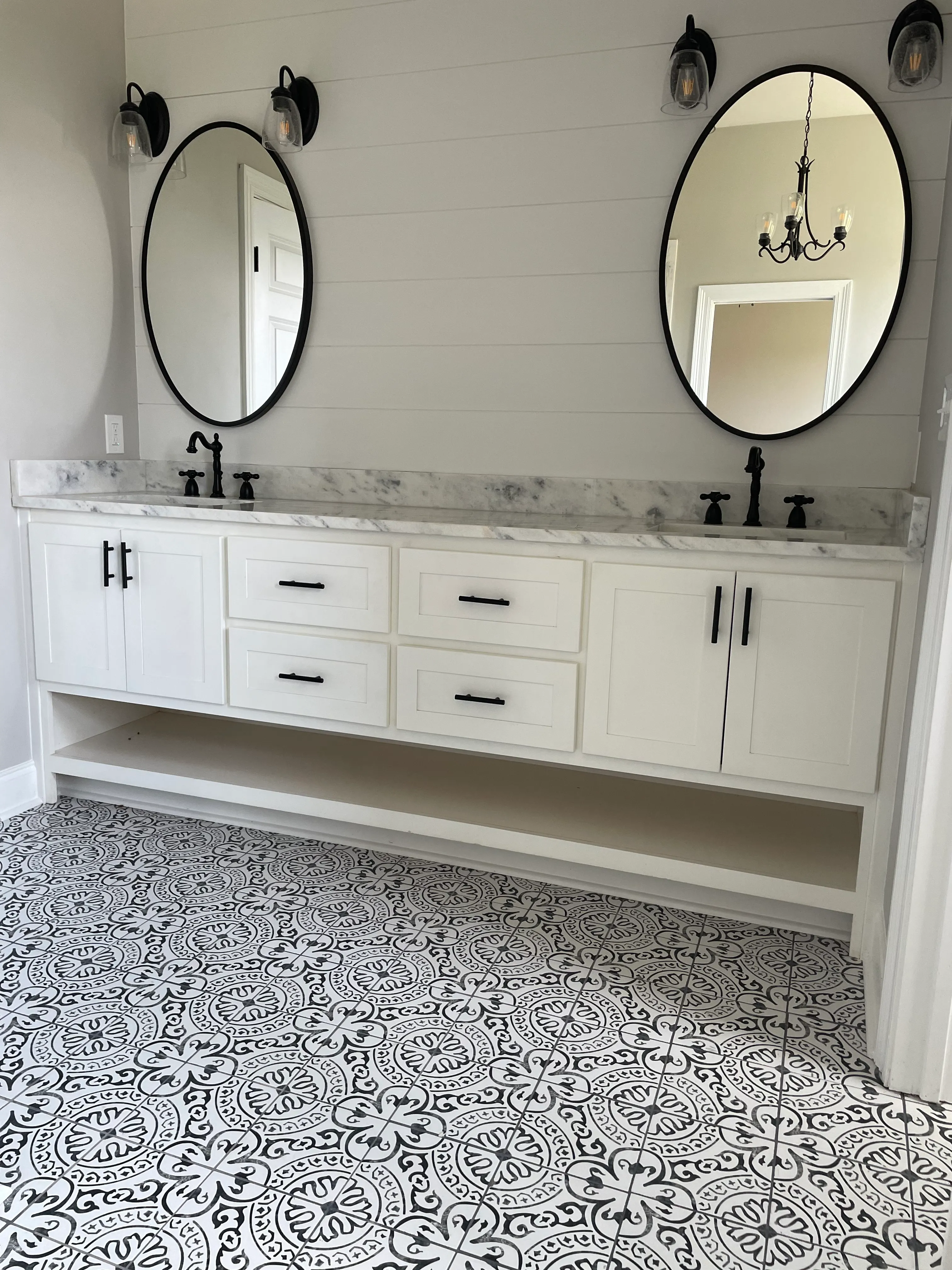 Custom bathroom vanity with white shaker cabinets and patterned tile by Alvarez Construction